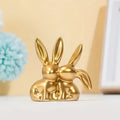 1 pieza Figura coleccionable, Adorno dorado de doble conejo lindo, artículo decorativo creativo para el escritorio del hogar.